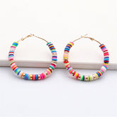 Eye-catching hoop earrings crafted from wood and metal, embellished with polymer clay and 18K gold-plated beads.